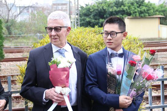 臺灣25歲青年趙守泉(右)與76歲英國老爹Andy(左)108年2月在苗栗家鄉舉辦婚禮,事隔約一年,兩人在苗栗市戶政事務所完成登記,成爲合法同婚伴侶。圖爲108年兩人公開接受衆人獻花祝福。中央社記者管瑞平攝 109年2月14日