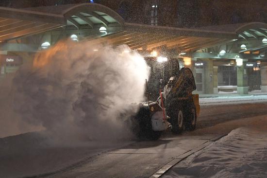 大雪紛茫，紐約州奧爾巴尼國際機場員工20日忙著剷雪。（美聯社）