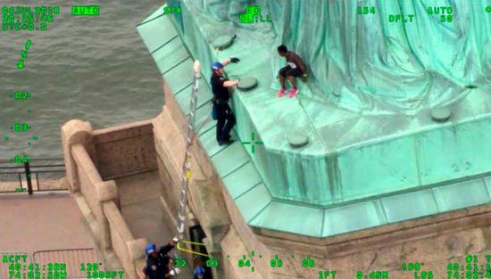 去年7月4日美國國慶日,奧庫穆(Therese Patricia Okoumou)爲抗議美國移民政策,攀爬自由女神像的底座。 美聯社資料照片