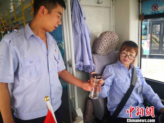 圖爲炎熱的夏天,交接班時,閆文剛爲妻子遞上一杯水。 史靜靜 攝