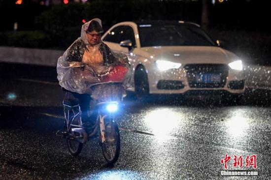 4月11日晚,一名女子駕駛電動車行駛在雨中。當晚,廣州市區出現強降水和雷雨大風等強對流天氣。<a target='_blank' href='http://www.chinanews.com/'>中新社</a>記者 陳驥旻 攝