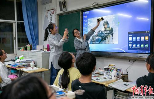 6月4日,雲南祿勸一中高三文科網絡培優班的同學們最後一次在教室集體晚自習。他們用黑板上的屏幕播放音樂,並與班上在外地參加高考的同學視頻,彼此加油。這塊用於網絡直播教學的屏幕,伴隨他們從高一到高三。