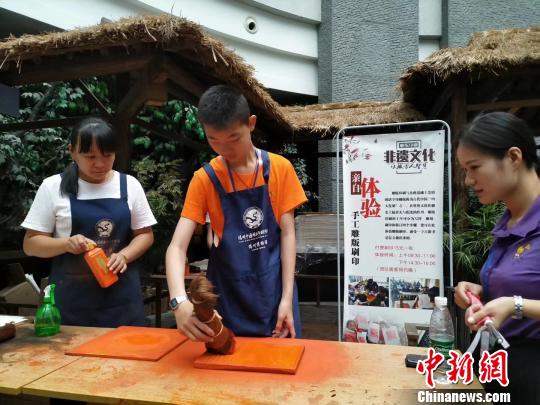 图为华裔青少年体验雕版印刷。 朱建兵 摄