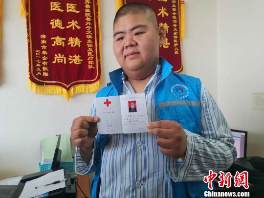 王浩楠已經成爲中國紅十字會志願者,經常參加各種公益活動,科普肥胖危害、分享減肥經驗,希望通過這種方式幫助更多“胖友”瘦身成功,擁有健康身體。圖爲王浩楠和他的志願者證。 郝學娟 攝