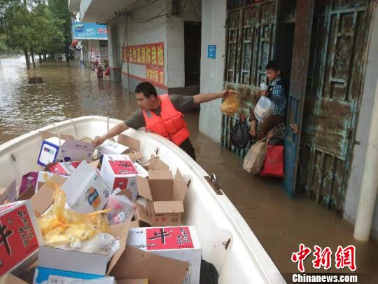 7月11日,江西省新餘市救援人員爲被困家中的居民送去食物和純淨水。 鍾欣 攝