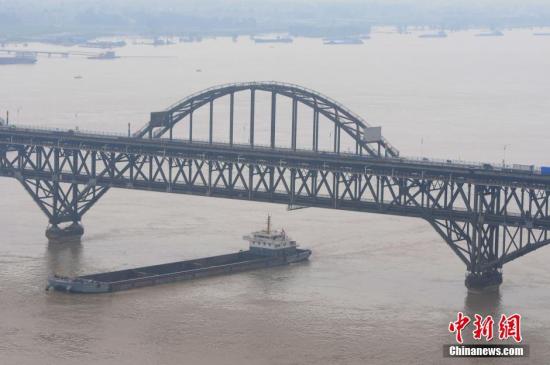 圖爲7月5日,船隻駛過超警戒線水位的長江江西九江段。 胡國林 攝