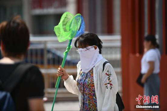 8月1日,北京高温天气持续,出行的市民用各种装备来遮挡炙热的阳光。<a target='_blank' href='http://www.chinanews.com/'>中新社</a>记者 张兴龙 摄