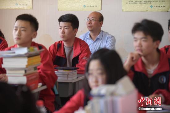 随着高考日益临近,王世卿利用工作生活中的零散时间复习备考,每晚会做模拟习题,有时也会与高考生一同上课学习。图为“高考哥”王世卿与高三学生一同上课备考。<a target='_blank' href='http://www.chinanews.com/'>中新社</a>记者 武俊杰 摄