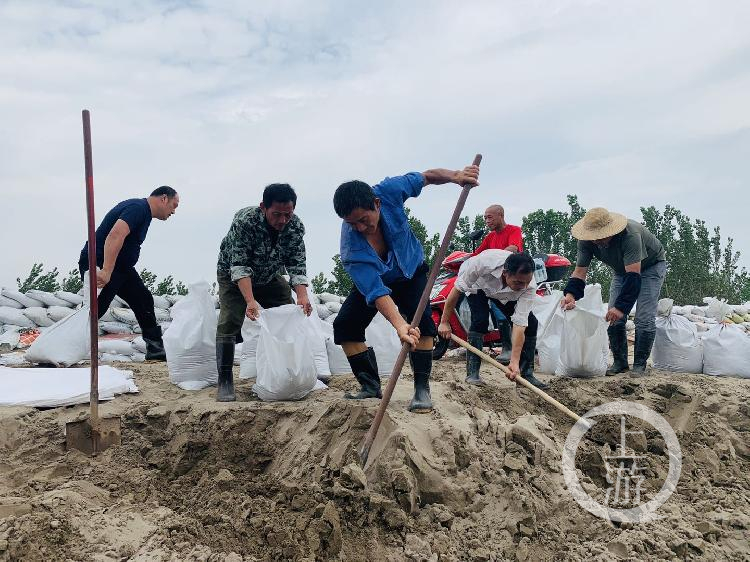 ▲7月13日,江西九江市江洲鎮,當地村民正在裝沙袋堤壩修築。攝影/上游新聞記者 時婷婷
