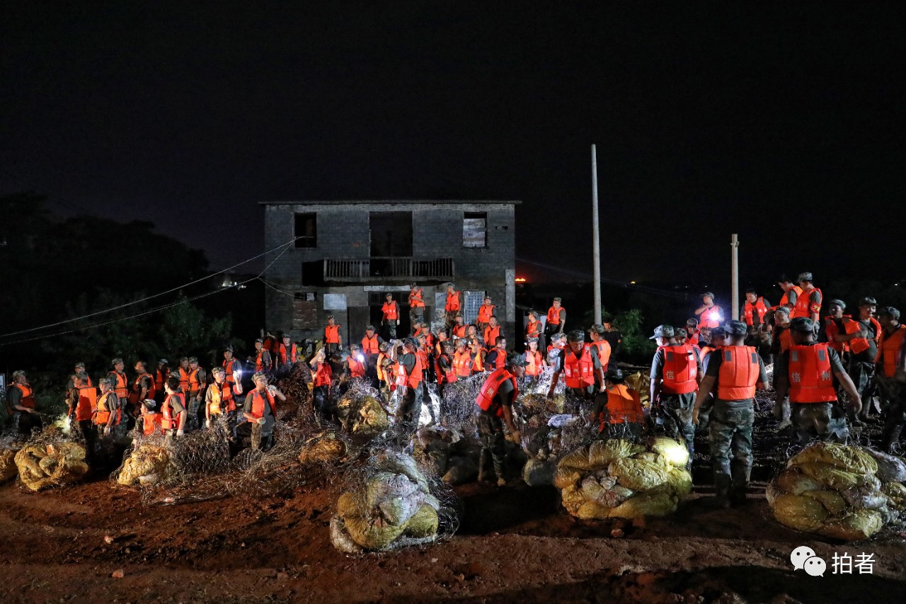 △ 7月12日晚,鄱陽縣饒河聯圩,武警江西總隊機動支隊的官兵和民兵正在用鐵絲製作大沙包。這些大沙包將用於加固防護,防止饒河河水倒灌。