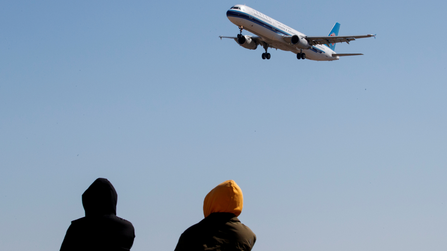 圖爲3月13日,人們看着中國南方航空公司的航班降落在北京首都國際機場。(圖片來源:路透社資料圖)