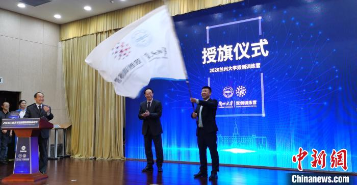 图为李玉民为兰州大学科技园有限责任公司总经理邓毓博授营旗。 魏建军 摄