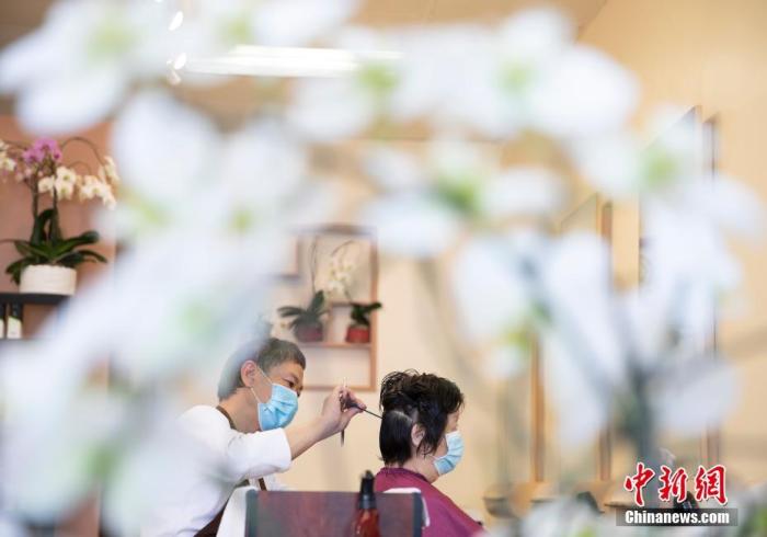 资料图:当地时间9月15日,顾客在美国旧金山一家理发店内理发。从9月14日开始,旧金山的理发店、美甲店、健身房以及酒店等商业店铺获准重启室内营业。 中新社记者 刘关关 摄