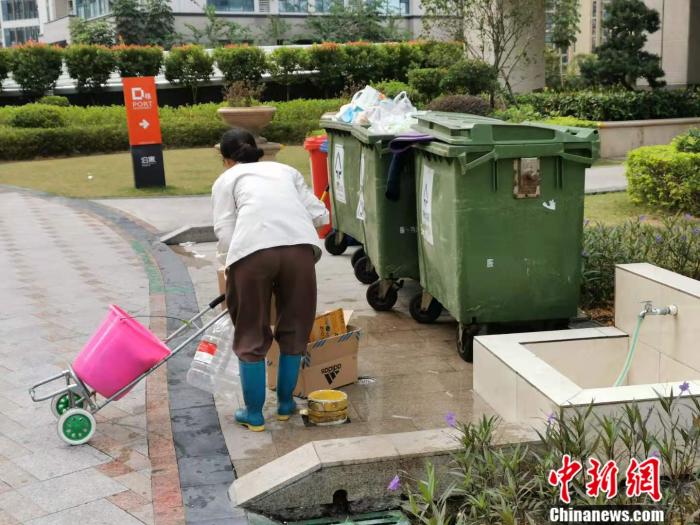 深圳一居民區附近,有人正在撿拾廢棄的快遞盒。 受訪者供圖