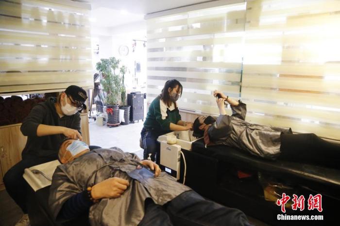 資料圖:市民佩戴口罩來到理髮店理髮,店員佩戴口罩進行服務。中新社記者 馬銘言 攝