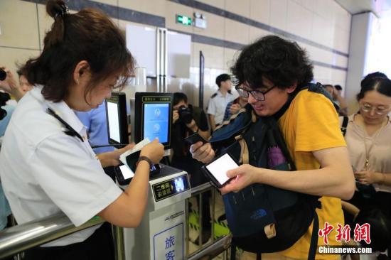 資料圖:旅客使用護照及二維碼車票確認信息後上車。殷立勤 攝