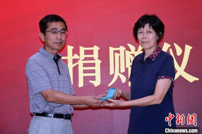 中科院大气所党委书记陆日宇(左)接受顾震潮先生二女儿顾英捐赠顾先生所获的第一届中国科学院科学奖章。 孙自法 摄