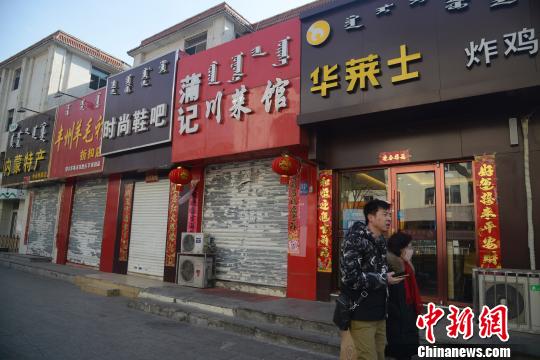 中山路上,民衆從貼春聯的商鋪門口經過。 劉文華 攝