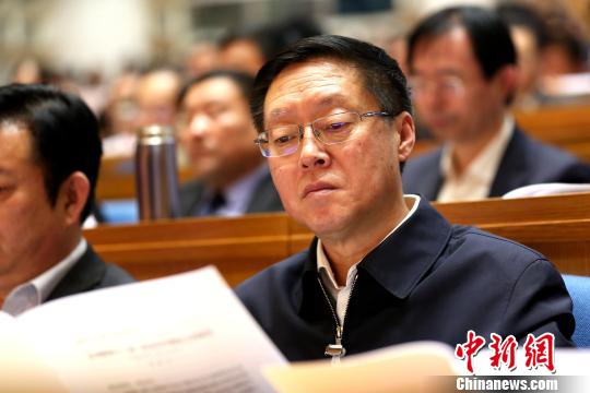 圖爲與會政協委員在現場閱讀會議文件。 樑犇 攝