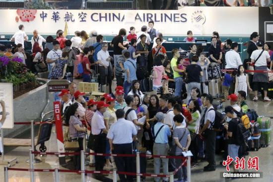 資料圖:桃園機場內,中華航空公司服務檯前諮詢航班信息或改簽航班的旅客排起百餘米的長隊。 <a target='_blank' href='http://www.chinanews.com/'>中新社</a>記者 陳小願 攝