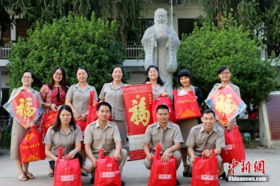 广西海外交流协会相关负责人介绍,2018—2019年度,广西共选派107名外派教师赴老挝、柬埔寨、泰国、菲律宾、印尼等国援教,他们的辛勤付出,为华文教育事业发展和中华文化的海外传承做出了特殊贡献。2019年农历春节前夕,广西相继给这些外派教师和40所海外华校、华教组织寄送了春联、灯笼、台历、福字帖、年画、窗花等新春贺礼,希望他们感受到来自中国的祝福及问候。图为老挝万象寮都公学外派教师与礼包合影。<a target='_blank' href='http://www.chinanews.com/'>中新社</a>发 钟欣 摄