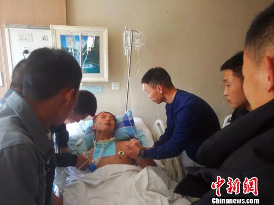 张辉所在的山西太谷消防大队、中队全体队友,连续41天深情呼唤,终于将其唤醒。图为刚刚执行完乡宁县山体滑坡救援增援任务的队友看望张辉。 陆祁国 摄