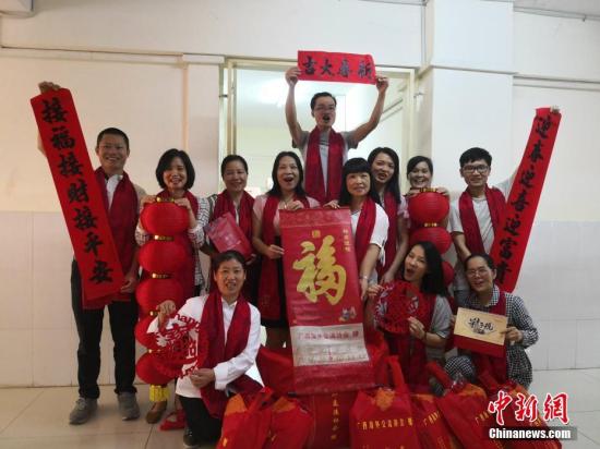 广西海外交流协会相关负责人介绍,2018—2019年度,广西共选派107名外派教师赴老挝、柬埔寨、泰国、菲律宾、印尼等国援教,他们的辛勤付出,为华文教育事业发展和中华文化的海外传承做出了特殊贡献。2019年农历春节前夕,广西相继给这些外派教师和40所海外华校、华教组织寄送了春联、灯笼、台历、福字帖、年画、窗花等新春贺礼,希望他们感受到来自中国的祝福及问候。图为柬埔寨端华学校外派教师与礼包合影。<a target='_blank' href='http://www.chinanews.com/'>中新社</a>发 钟欣 摄