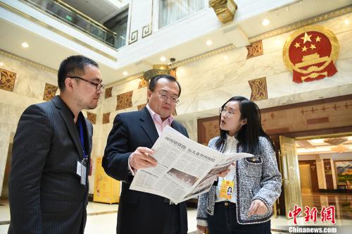 资料图:2018年3月10日,全国人大代表,浙江省纪委书记、浙江省监察委员会主任刘建超(中)翻阅《中国新闻》。 <a target='_blank' href='http://www.chinanews.com/'>中新社</a>记者 侯宇 摄