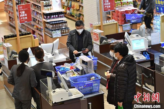 資料圖:居民戴口罩外出購物。(圖片來源:中新社)