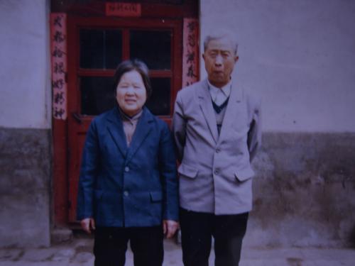 1984年離休後,周老與老伴在老房子前的合影。受訪者供圖