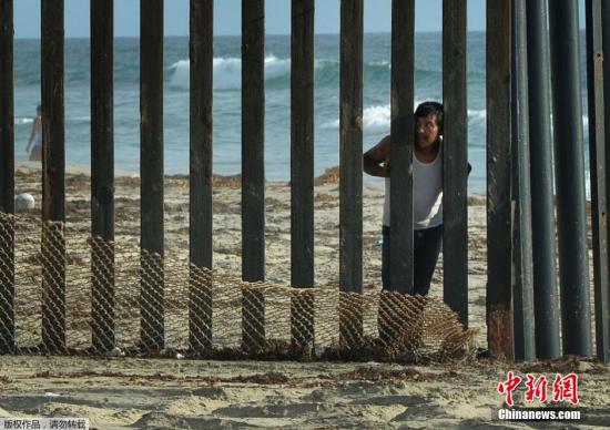 資料圖：一道劃分美墨邊界的柵欄旁，一名男子站在墨西哥這邊眺望美國。
